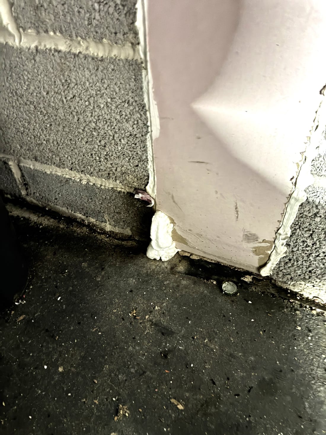 Close view of the concealed mouse entry route into the apartment block structure